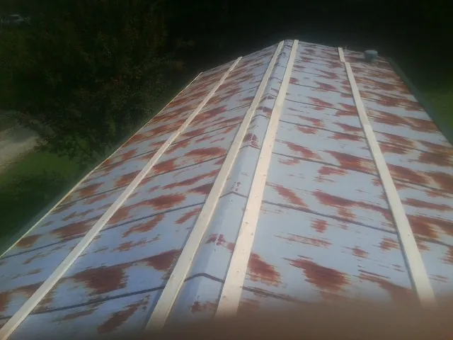 Rusted metal roof panels with new wood purlins before replacement — Storm Damage Roof Repair in Briceville by Roofing Brothers