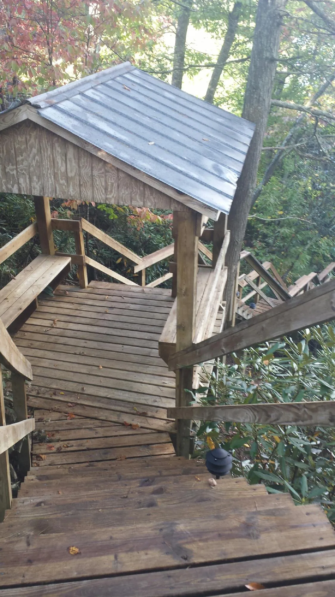 Metal roofed shelter over wooden steps on a wooded walkway — Skylight Repair & Installation work by our crew in Briceville