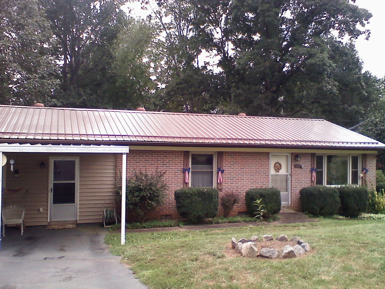 Bronze metal roof and carport on a brick ranch home — Roof Repair work by our crew in Briceville