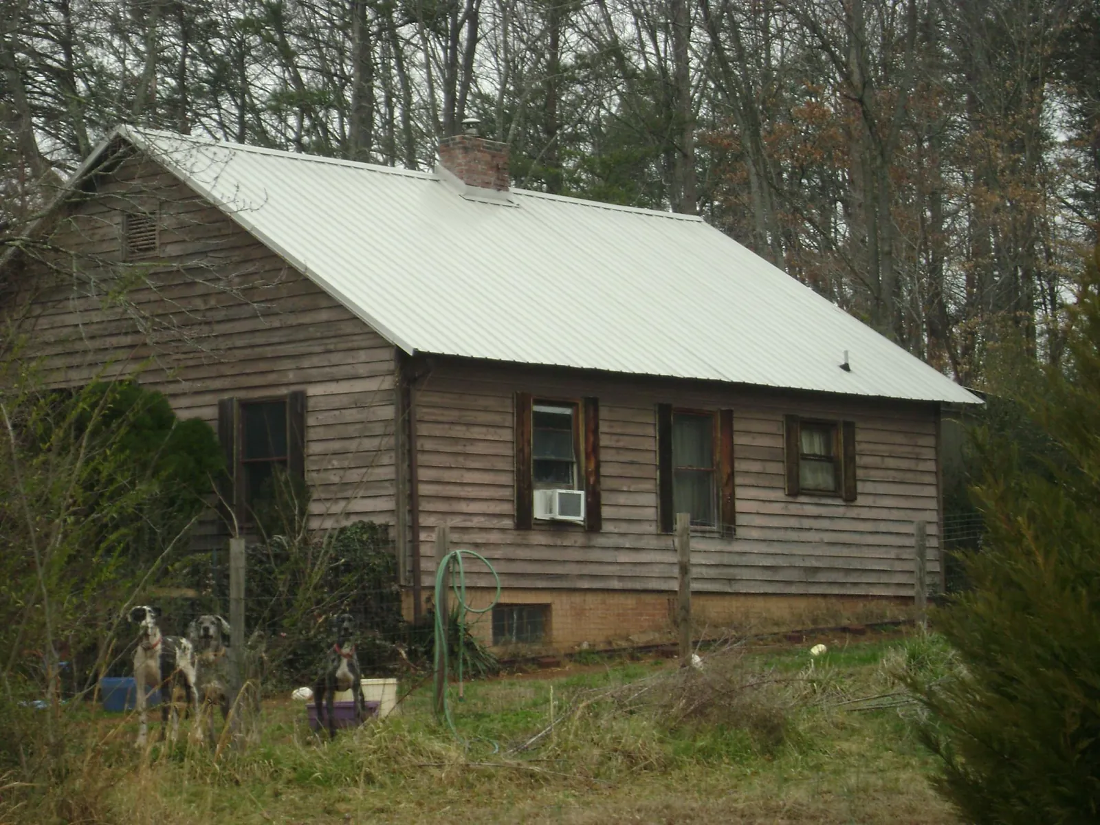 White metal roof on an old wood sided farmhouse, from a Metal Roof Installation job in Briceville